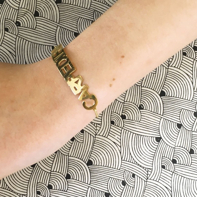 Gold articulated Carpe Diem bracelet worn on wrist