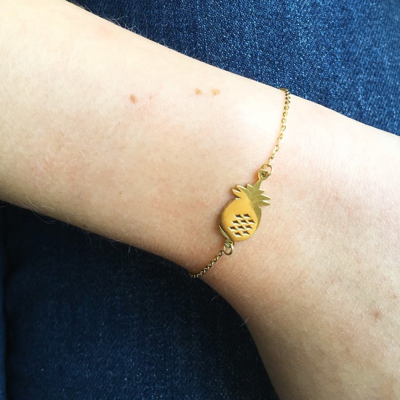 Gold pineapple bracelet worn on wrist